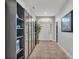 Long hallway featuring tile floors, neutral walls, and modern shelving units at 2726 Greyhawk Estates Ln, Lakeland, FL 33812