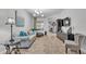 Inviting living room featuring tile floors, modern light fixture, and comfortable gray sofa at 2726 Greyhawk Estates Ln, Lakeland, FL 33812