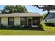 Charming screened in back porch surrounded by mature landscaping with a grassy yard at 29 Buck Cir, Haines City, FL 33844