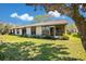 Rear exterior view of the home showcasing a well-maintained lawn and inviting screened patio area at 29 Buck Cir, Haines City, FL 33844