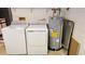 Close-up of the laundry room with water heater and washer and dryer appliances at 29 Buck Cir, Haines City, FL 33844