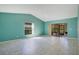 Bright living room featuring sliding glass doors and neutral tile flooring under a vaulted ceiling at 29 Buck Cir, Haines City, FL 33844