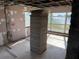 Unfinished basement area with a large stack of construction materials by two windows overlooking the lake at 330 Callitris Ave, Polk City, FL 33868