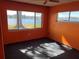 Bedroom featuring orange walls and two windows offering views of the lakefront at 330 Callitris Ave, Polk City, FL 33868