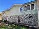 Side exterior of a two-story home featuring a stone foundation and siding at 330 Callitris Ave, Polk City, FL 33868