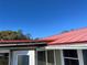 Durable metal roof and white trimmed windows under a clear blue sky enhance the home's curb appeal at 330 Callitris Ave, Polk City, FL 33868