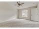 Bright bedroom featuring plush carpet, a ceiling fan, and a large window at 3815 Horizon View Loop, Lakeland, FL 33813