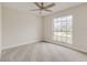 Comfortable bedroom featuring plush carpet, a ceiling fan, and a large window at 3815 Horizon View Loop, Lakeland, FL 33813