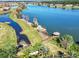 Aerial view of waterfront with a charming gazebo at the end of a wooden pier, surrounded by lush greenery at 3965 Aquilla Dr, Lakeland, FL 33810