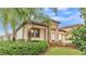 A front exterior view of a home that features stone accents, a terracotta roof, and a well manicured lawn at 3965 Aquilla Dr, Lakeland, FL 33810