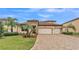 A front view of a home with a terracotta roof, stone accents, and a 3-car garage at 3965 Aquilla Dr, Lakeland, FL 33810