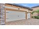 A front view of a 3-car garage that features stone accents and black hardware at 3965 Aquilla Dr, Lakeland, FL 33810