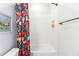 Bright bathroom features a tiled shower and a cheerful floral shower curtain at 4525 Breccia Ln, Lakeland, FL 33811