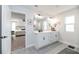 Bright bathroom featuring patterned tile floors, white cabinetry, double vanity and a view into the main bedroom at 4525 Breccia Ln, Lakeland, FL 33811