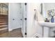 Chic powder room with pedestal sink, round mirror, and a view of the home's staircase at 4525 Breccia Ln, Lakeland, FL 33811