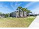 View of the pool house surrounded by lush green grass and palm trees, enhancing the community's appeal at 4525 Breccia Ln, Lakeland, FL 33811