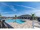 Community pool featuring a large pool, lounge chairs, covered lounge area and clear blue sky at 4525 Breccia Ln, Lakeland, FL 33811