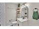 Half bathroom featuring a sink, toilet, accent wall, and decorative shelving at 4620 S Gary Ave, Lakeland, FL 33813