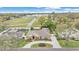 Aerial view of brick home, with a circular driveway, manicured lawn, and a nearby school at 4769 Highlands Place Cir, Lakeland, FL 33813