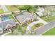 Aerial view of home featuring a large driveway, mature landscaping and screened-in pool at 4769 Highlands Place Cir, Lakeland, FL 33813