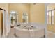 Bathroom jacuzzi tub beneath arched windows offering natural light and a view of the outdoors at 4769 Highlands Place Cir, Lakeland, FL 33813