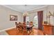 Formal dining room featuring hardwood floors, ornate chandelier, and natural light from the large arched windows at 4769 Highlands Place Cir, Lakeland, FL 33813