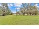 Sprawling property showcasing a home, large green lawn, outbuildings and mature trees at 5062 1St Nw St, Lakeland, FL 33810