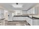 Well-lit kitchen with white cabinets, countertops, stainless steel appliances, and dark-colored flooring at 5062 1St Nw St, Lakeland, FL 33810