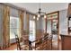 Formal dining room featuring hardwood floors, a wooden table, and large windows with floral curtains at 5118 Eagles Nest Dr, Lakeland, FL 33810