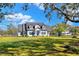 Charming two-story home with blue front door and expansive, well-manicured lawn at 5118 Eagles Nest Dr, Lakeland, FL 33810