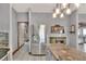 Spacious kitchen area featuring stainless steel refrigerator, tile flooring, granite countertops, and modern lighting fixtures at 5118 Eagles Nest Dr, Lakeland, FL 33810