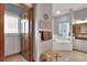 En-suite bathroom with tiled floor, soaking tub with glass block window, and vanity with decorative mirror at 5118 Eagles Nest Dr, Lakeland, FL 33810