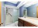 Well-lit bathroom with a blue accent wall and a glass enclosed shower at 5225 Imperial Lakes Blvd # 49, Mulberry, FL 33860