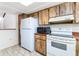 Functional kitchen features white appliances, tiled floor, and light-colored wooden cabinetry at 5225 Imperial Lakes Blvd # 49, Mulberry, FL 33860