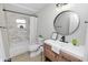 Stylish bathroom featuring a tub, a round mirror over a modern vanity, and marble-look shower tile at 5252 Montserrat Dr, Lakeland, FL 33812