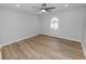 Spacious bedroom featuring wood-look flooring, modern ceiling fan, and arched window for natural light at 5252 Montserrat Dr, Lakeland, FL 33812