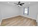 Bright, empty bedroom with hardwood floors, a ceiling fan, a window with curtains, and neutral wall paint at 5252 Montserrat Dr, Lakeland, FL 33812