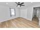 Bright bedroom with wood floors, a ceiling fan, a window with curtains, and a double door closet at 5252 Montserrat Dr, Lakeland, FL 33812