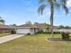 Charming single-story home with a well-manicured lawn and a spacious two-car garage, framed by a mature palm tree at 5252 Montserrat Dr, Lakeland, FL 33812