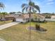 Lovely home featuring a well-maintained lawn, a driveway, and landscaping; tropical palm trees add to the appeal at 5252 Montserrat Dr, Lakeland, FL 33812