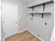 Laundry room featuring wood-look floors, floating shelves, and neutral-colored walls at 5252 Montserrat Dr, Lakeland, FL 33812