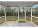 Enclosed back porch with concrete flooring surrounded by shrubs and trees at 5252 Montserrat Dr, Lakeland, FL 33812