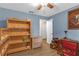 This blue bedroom features a ceiling fan, wooden furniture, and laminate floors at 531 Gibson S Rd, Lakeland, FL 33813