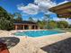 Community pool and hot tub surrounded by brick pavers and lush landscaping at 561 Lake Mystic Ln, Lakeland, FL 33813