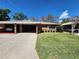 Charming brick home featuring a well-manicured lawn, carport and clear blue skies at 561 Lake Mystic Ln, Lakeland, FL 33813