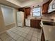 Well-lit kitchen featuring wood cabinets, white appliances, and stylish tile flooring at 561 Lake Mystic Ln, Lakeland, FL 33813