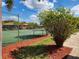 View of the community tennis courts with lush green surroundings and well-maintained fence at 561 Lake Mystic Ln, Lakeland, FL 33813