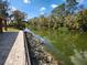 Scenic water view from a paved path bordered by lush trees and greenery at 561 Lake Mystic Ln, Lakeland, FL 33813