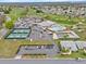 Aerial view of a golf course community with tennis courts, a pool, a clubhouse, a recreation building and green space at 5725 Mallard Dr, Lakeland, FL 33809