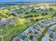 Aerial view of a golf course neighborhood with mature trees and green spaces, and views of a clubhouse and pool at 5725 Mallard Dr, Lakeland, FL 33809